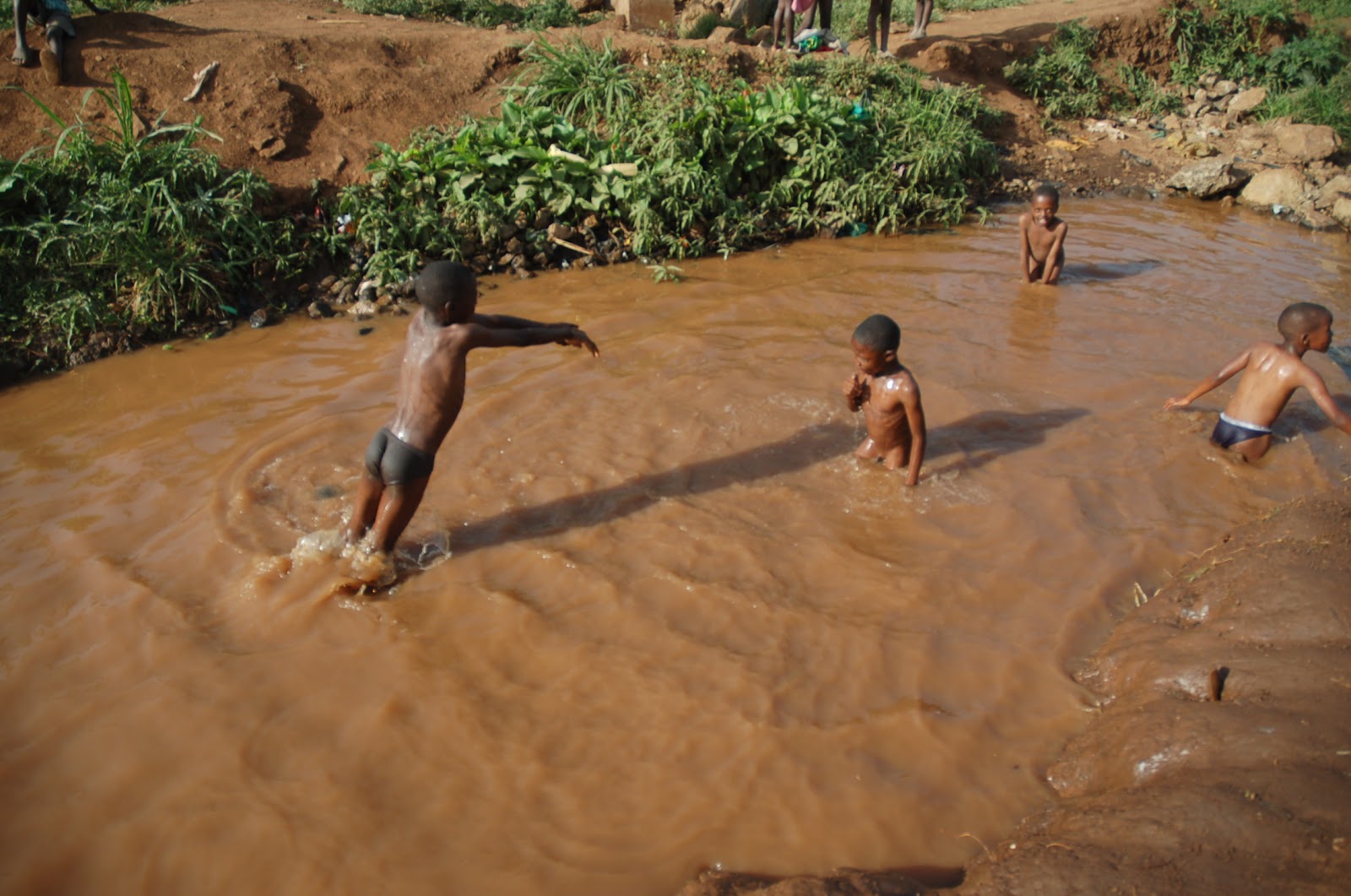Негритята купаются. Купание в Африке. Дети купаются в грязной воде. Купание в грязной реке.